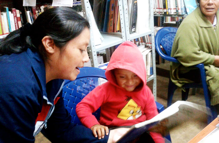 Rosa Myriam Ortega, bibliotecaria del resguardo Indígena de Mueses, Potosí (Nariño), leyendo con su hijo.